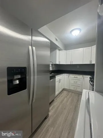 a kitchen with granite countertop a refrigerator and a sink