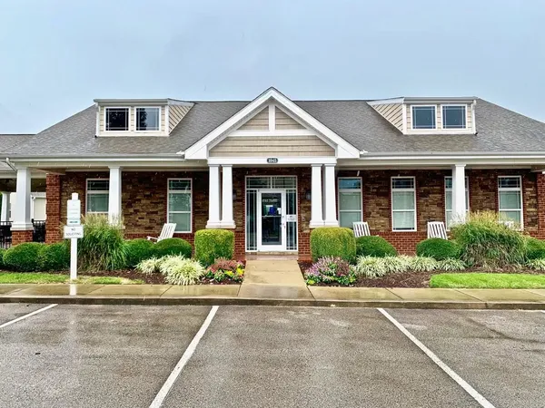 front view of a brick house with a yard