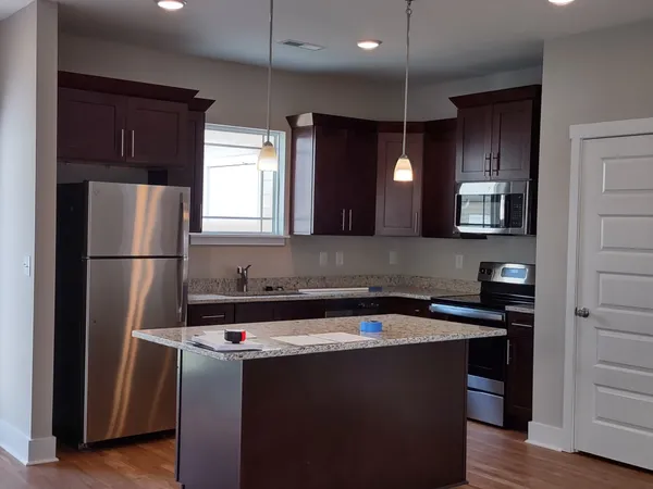 a kitchen with a refrigerator a sink and wooden cabinets