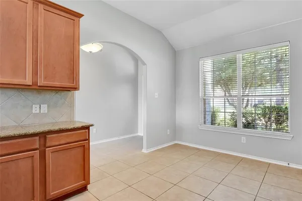 a view of a kitchen with white cabinets and a window