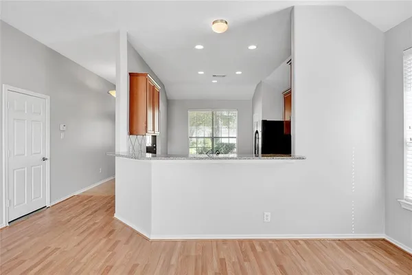 a living room with hard wood floors and a flat screen tv