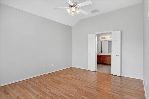 a view of a room with wooden floor and a ceiling fan