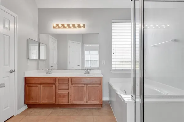 a spacious bathroom with a sink a mirror and a bathtub