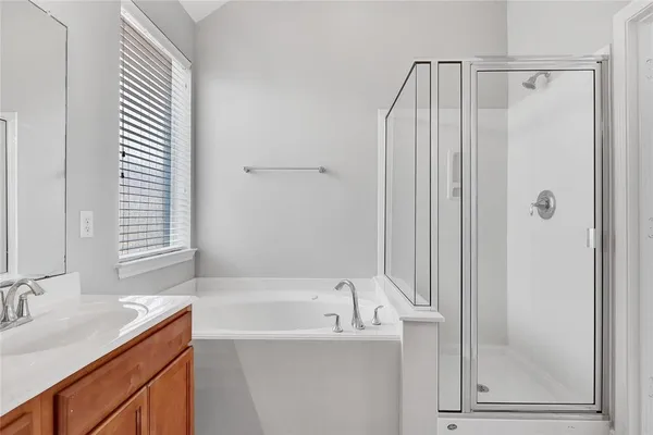 a bathroom with a granite countertop sink and a bathtub
