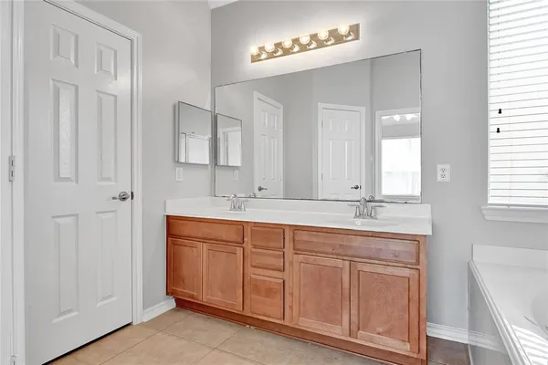 a bathroom with a double vanity sink and a mirror