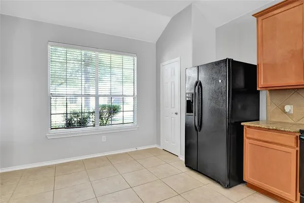a kitchen with a refrigerator and a stove top oven