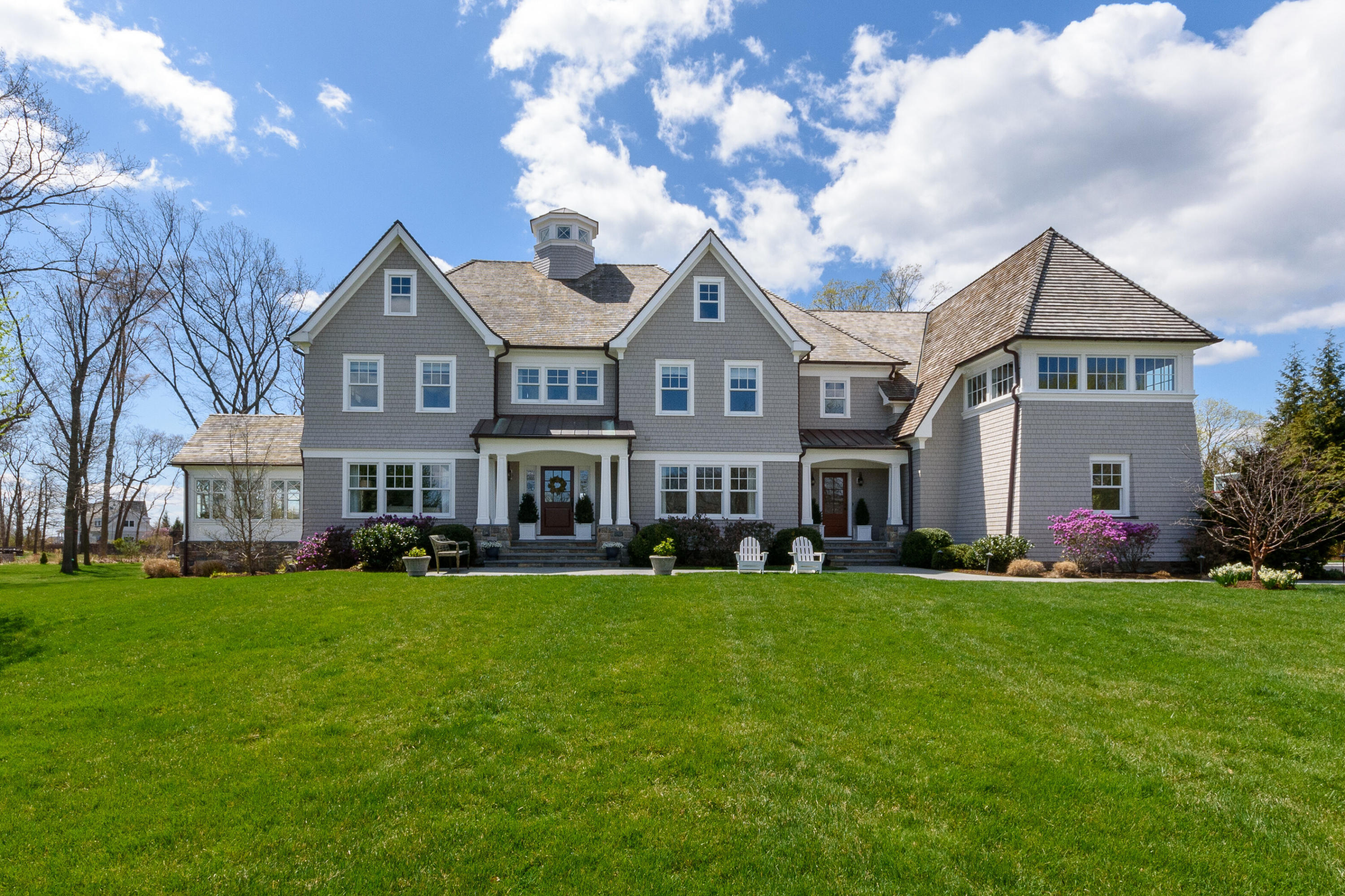 a front view of a house with a garden and trees