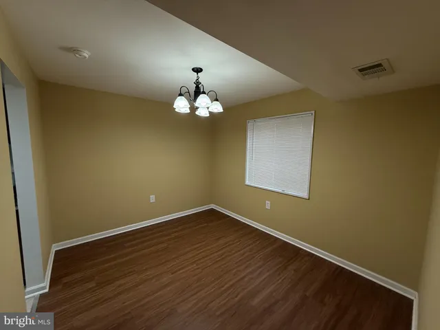 a view of wooden floor and chandelier in a room