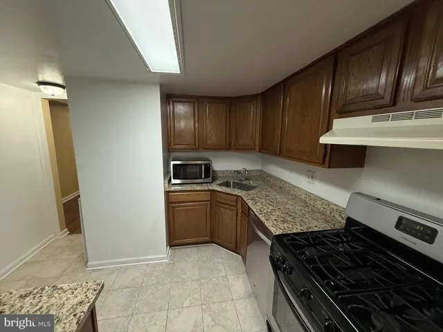 a kitchen with granite countertop stainless steel appliances and wooden cabinets