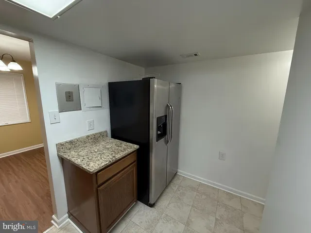 a kitchen with a wooden floor and refrigerator