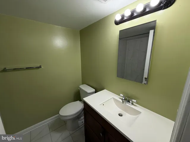 a bathroom with a sink mirror vanity and toilet