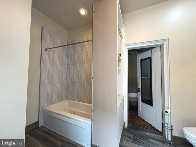a bathroom with a white bath tub and a white door