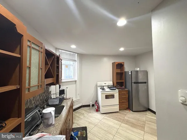 a kitchen with stainless steel appliances granite countertop a refrigerator sink and stove