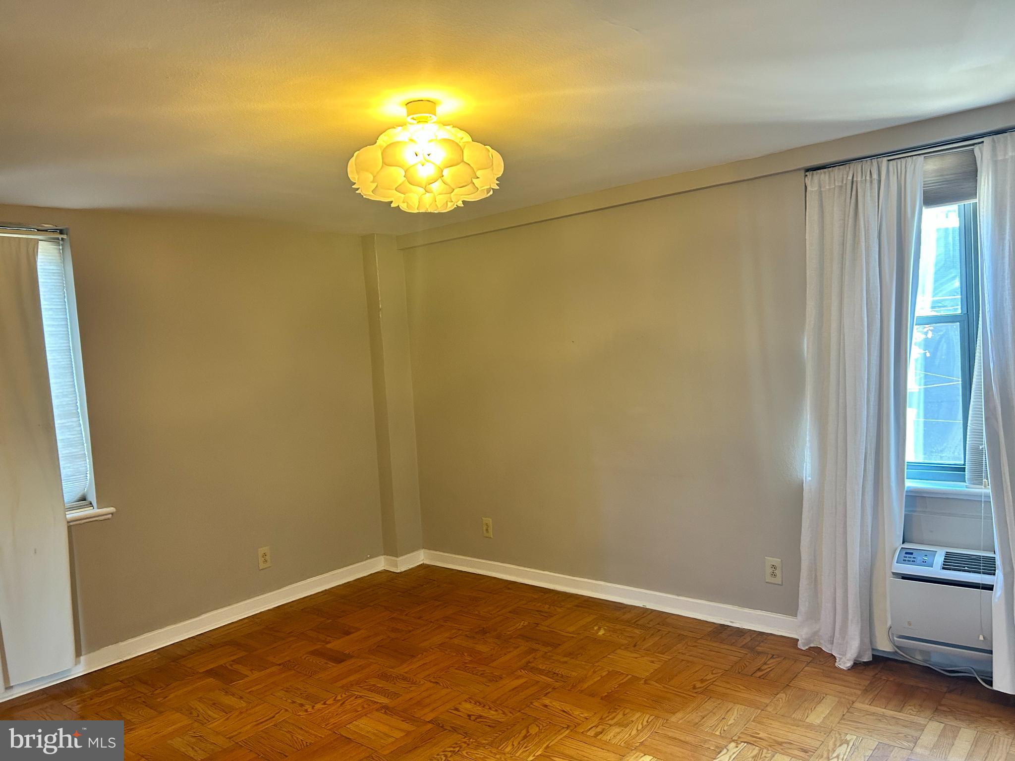 an empty room with a chandelier fan
