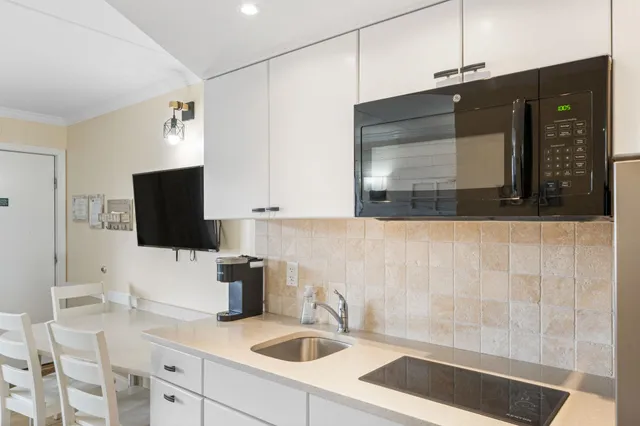 a kitchen with a sink and a stove top oven