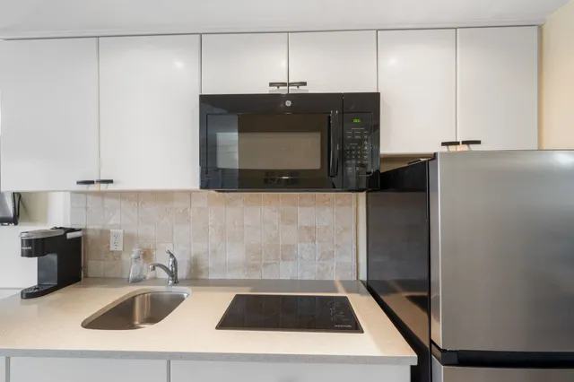 a kitchen with a sink and a stove top oven
