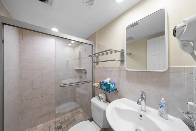 a bathroom with a shower sink and mirror