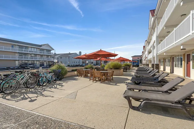 a view of a patio with a table and chairs under an umbrella with potted plants