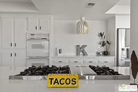 a kitchen with white cabinets and appliances