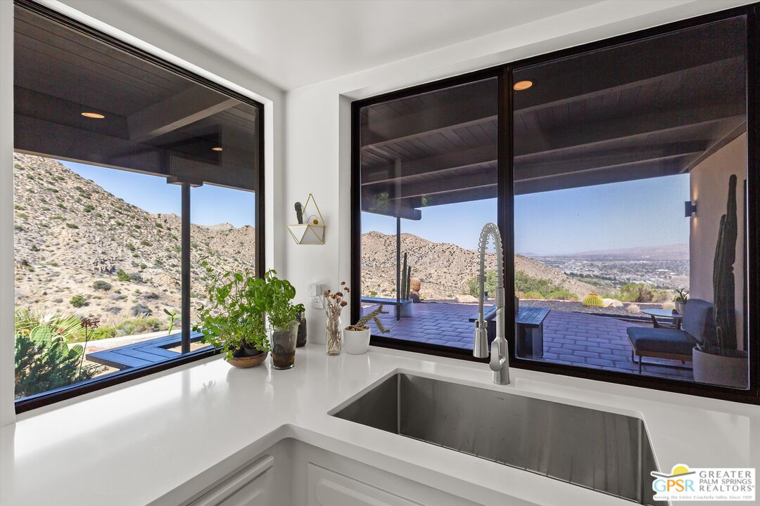 53744 Ridge Road Yucca Valley, CA 92284 - Photo 19 of 39 a kitchen with a large window and a potted plant