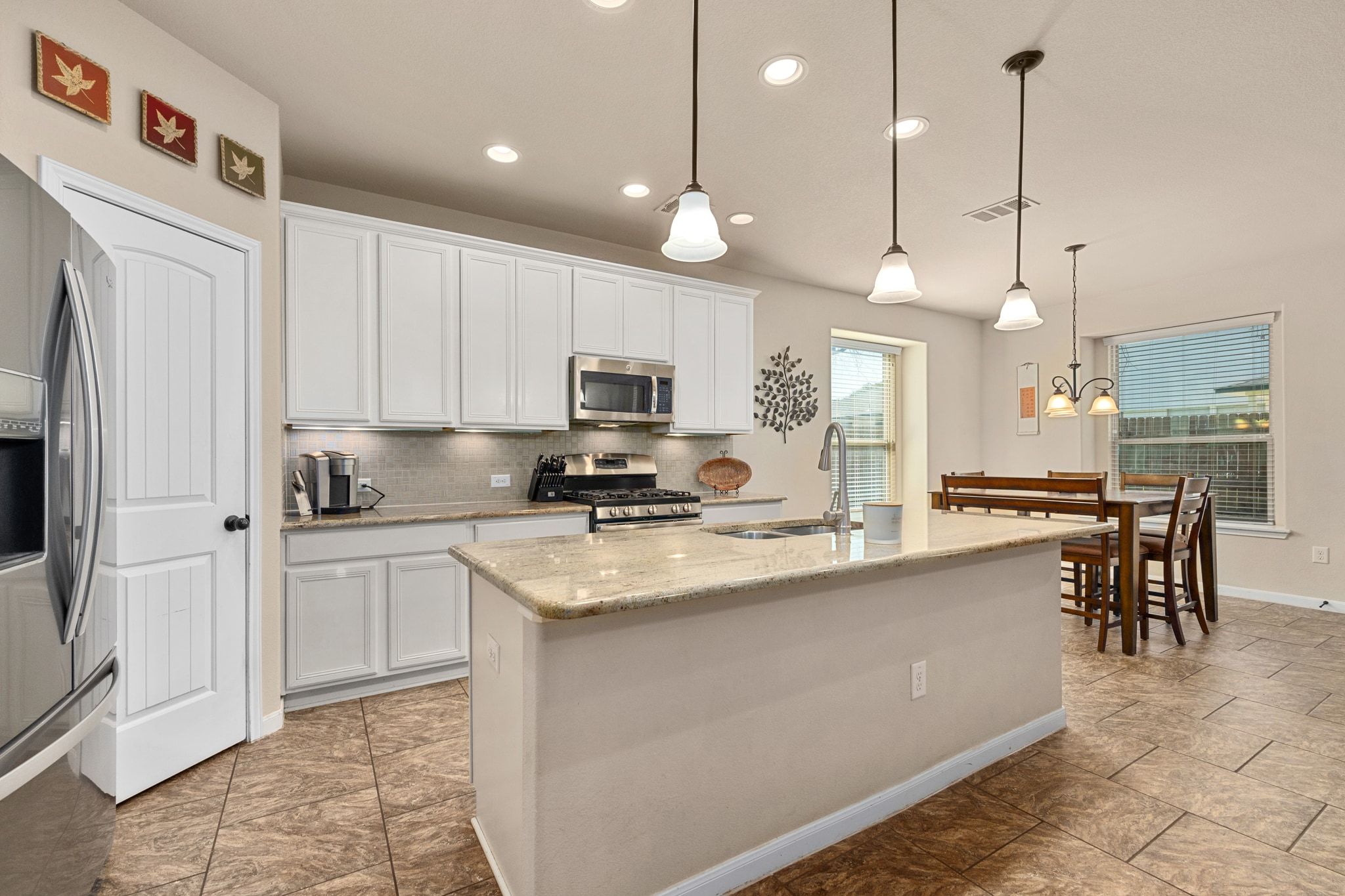 738 Palo Duro Loop Round Rock, TX 78664 - Photo 5 of 32 The kitchen is adorned with white cabinetry and a warm, neutral granite countertop.