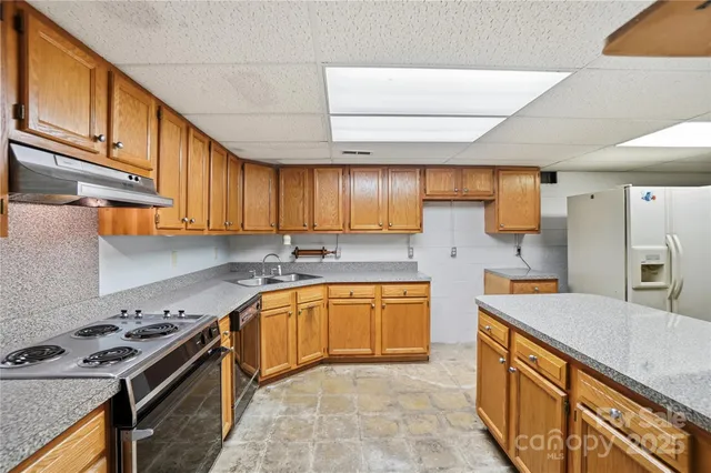 a kitchen with stainless steel appliances granite countertop a refrigerator a sink and dishwasher