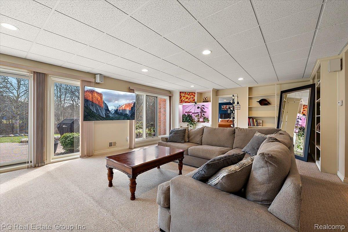 3571 Cedar Brook Drive Rochester, MI 48309 - Photo 47 of 57 Living room with carpet flooring, built in shelves, a drop ceiling, and recessed lighting