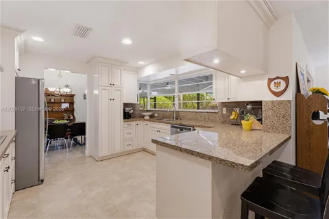 a kitchen with stainless steel appliances granite countertop a sink and a refrigerator