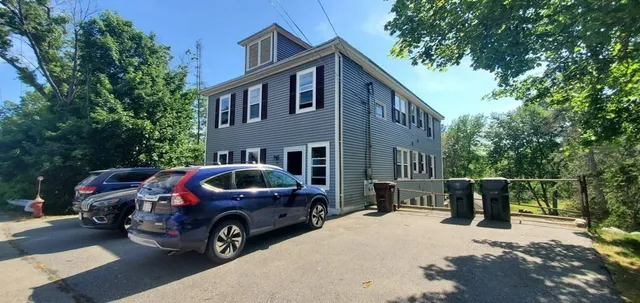 a view of a house with backyard and trees