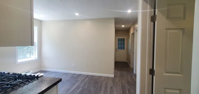 a view of a livingroom with wooden floor and a window