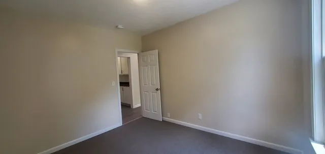 an empty room with a ceiling fan and a window