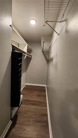 a view of a hallway with wooden floor and cabinet