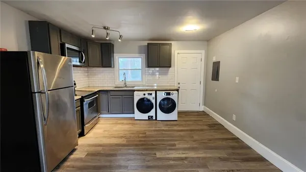 a view of a livingroom with a flat screen tv a ceiling fan and refrigerator
