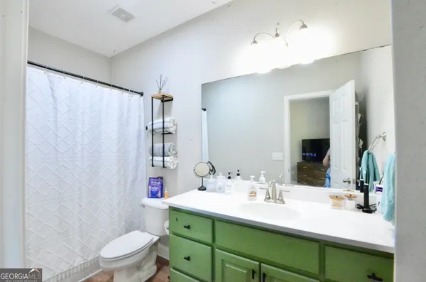 a bathroom with a sink vanity mirror and toilet