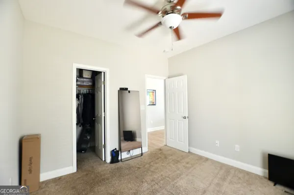 an empty room with closet and a chandelier fan