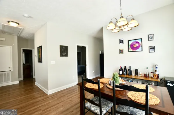 a view of a dining room with furniture wooden floor and a chandelier