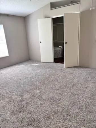 an empty room with closet and bathroom