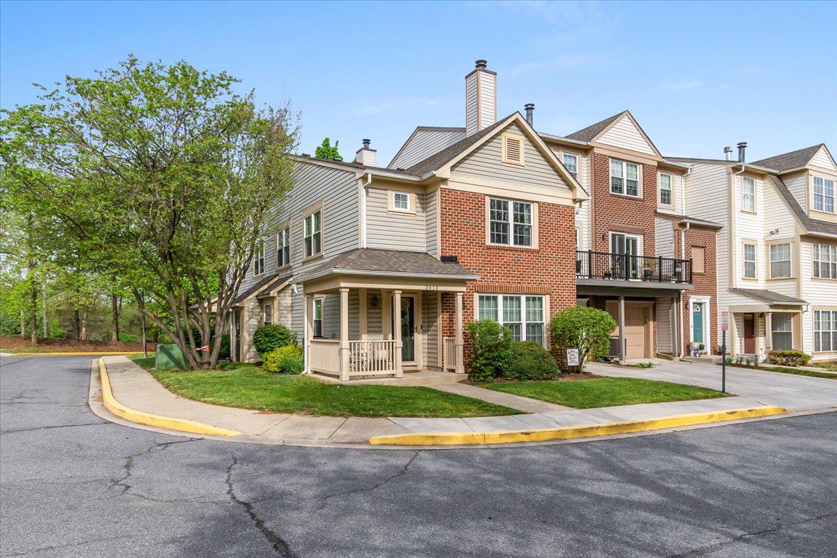 2610 Warren Way, Unit 37 Frederick, MD 21701 - Photo 39 of 42 a view of a brick house next to a yard with big trees