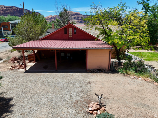 178 Walnut Lane Moab, UT 84532 - Photo 2 of 25 Red-painted exterior featuring a metal roof and a covered carport with exposed wood beams