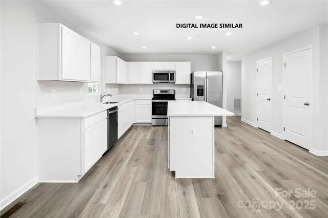 a large kitchen with a large counter top appliances and cabinets
