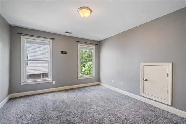 an empty room with a window and a fan