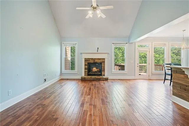 an empty room with windows and chandelier fan