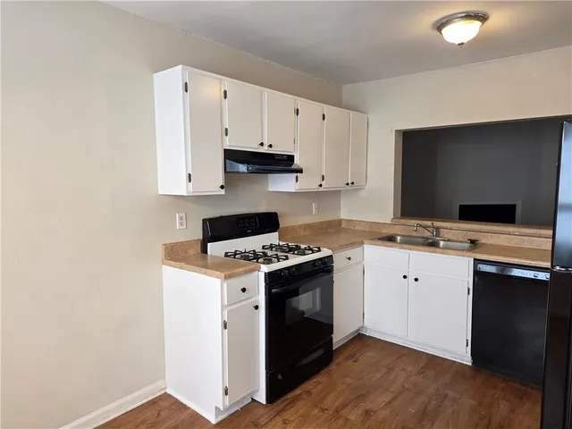 a kitchen with cabinets appliances and a sink