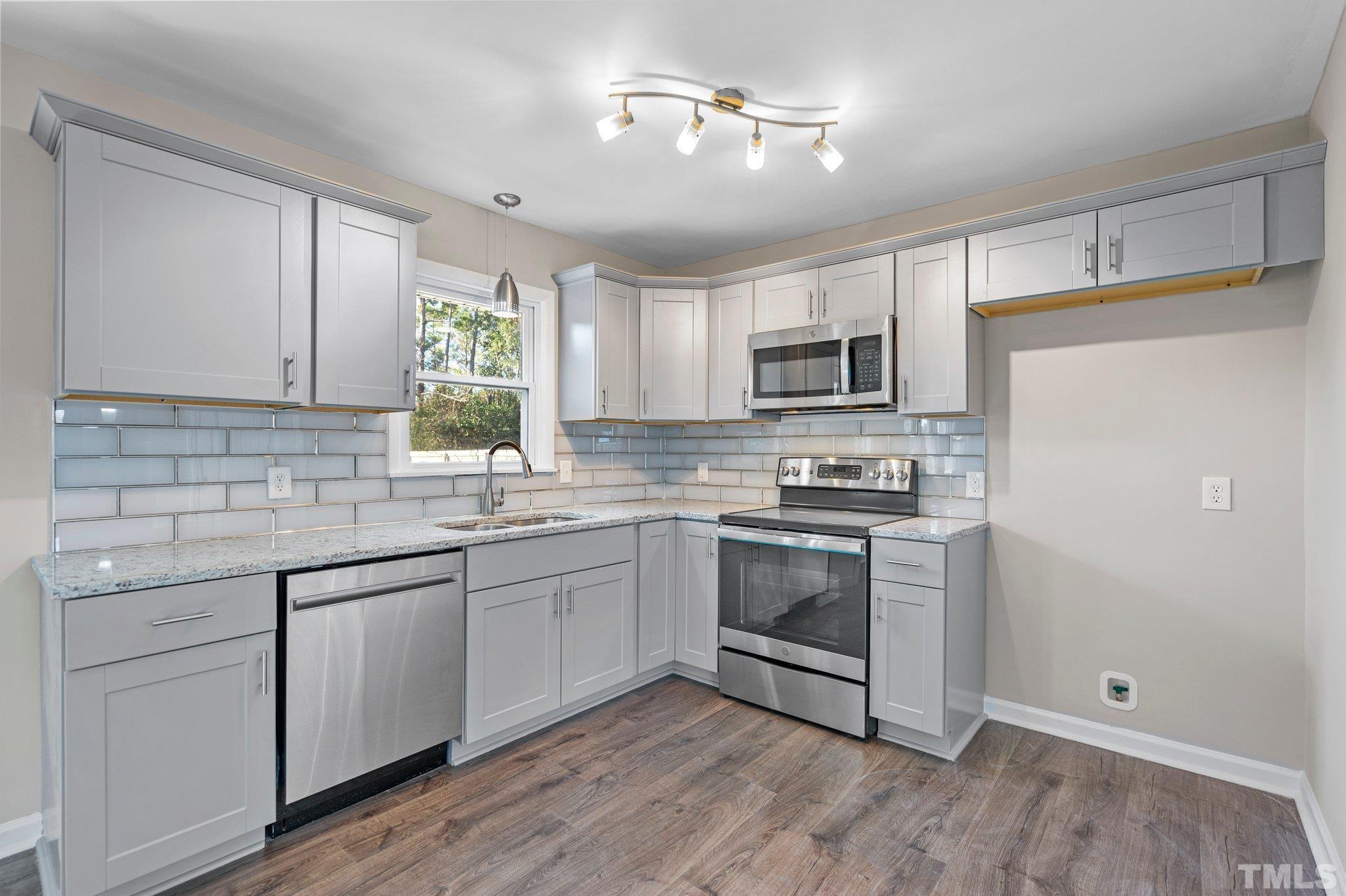 101 Holly Road Castle Hayne, NC 28429 - Photo 5 of 31 a kitchen with granite countertop white cabinets and stainless steel appliances