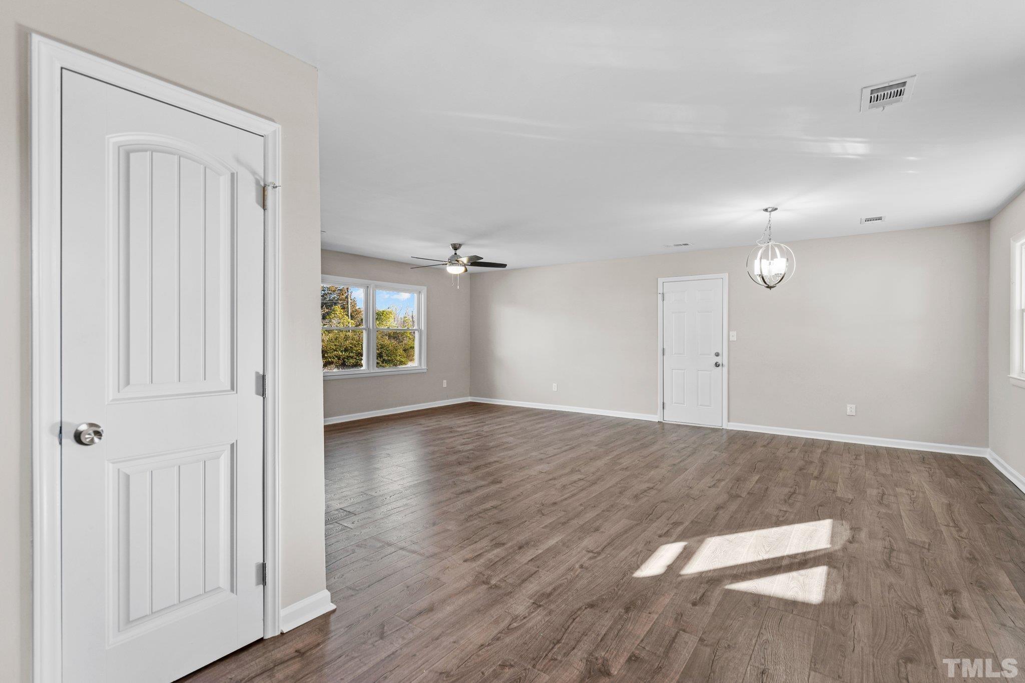 101 Holly Road Castle Hayne, NC 28429 - Photo 9 of 31 an empty room with wooden floor and windows
