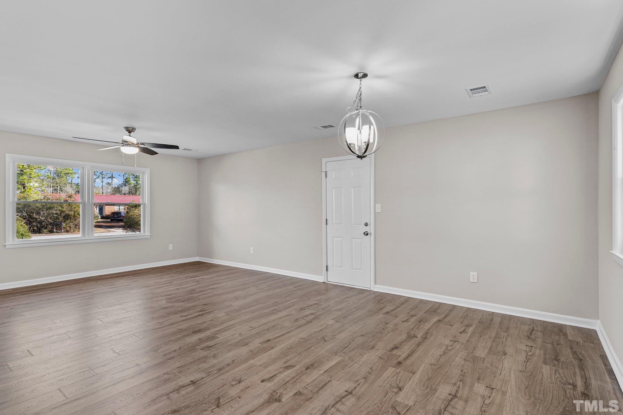 101 Holly Road Castle Hayne, NC 28429 - Photo 10 of 31 an empty room with wooden floor and windows
