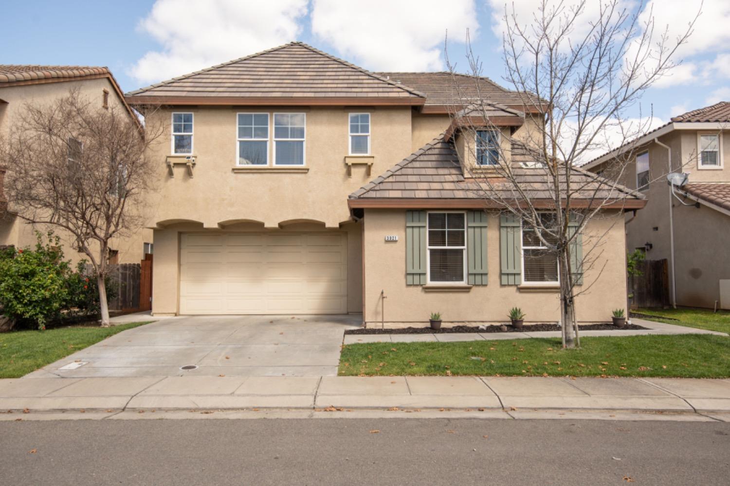 3921 Ruffed Grouse Lane Modesto, CA 95355 - Photo 1 of 1 a front view of a house with a garden and garage