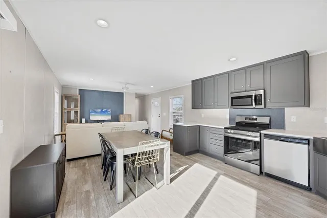 a kitchen with a table chairs microwave and cabinets