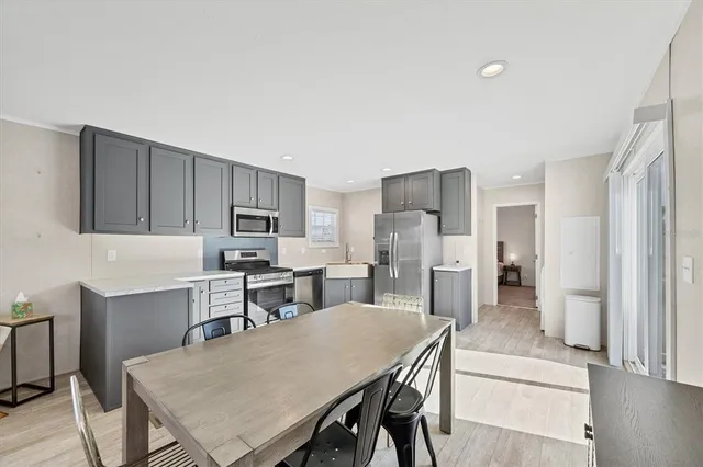 a kitchen with a table chairs refrigerator and cabinets