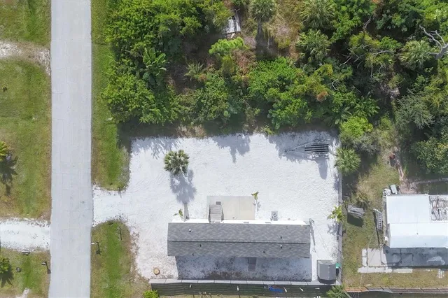 an aerial view of a house with a yard and large trees